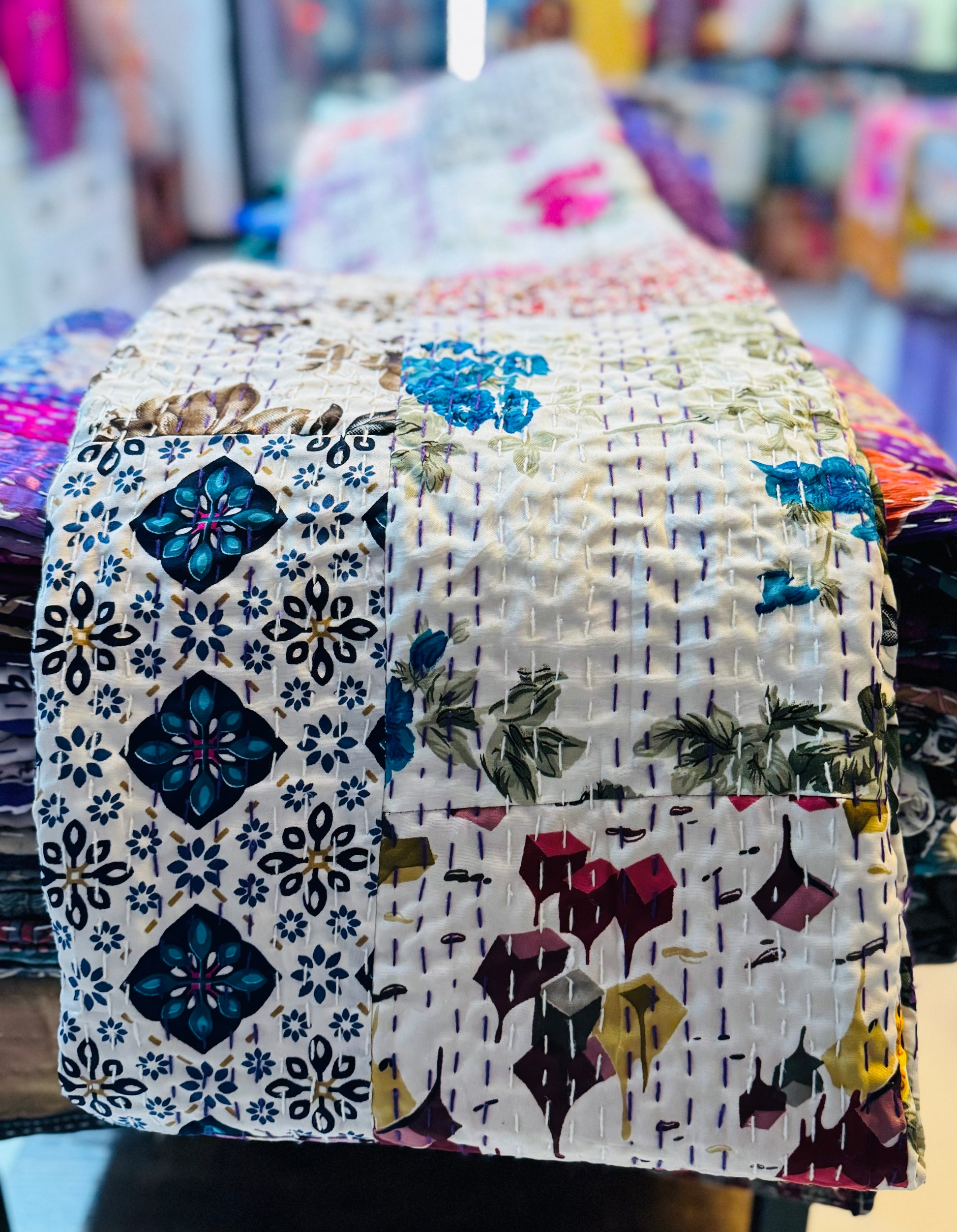 Beautiful shot of silk patchwork kantha quilt shows the combination of patches sewed together with kantha stitches