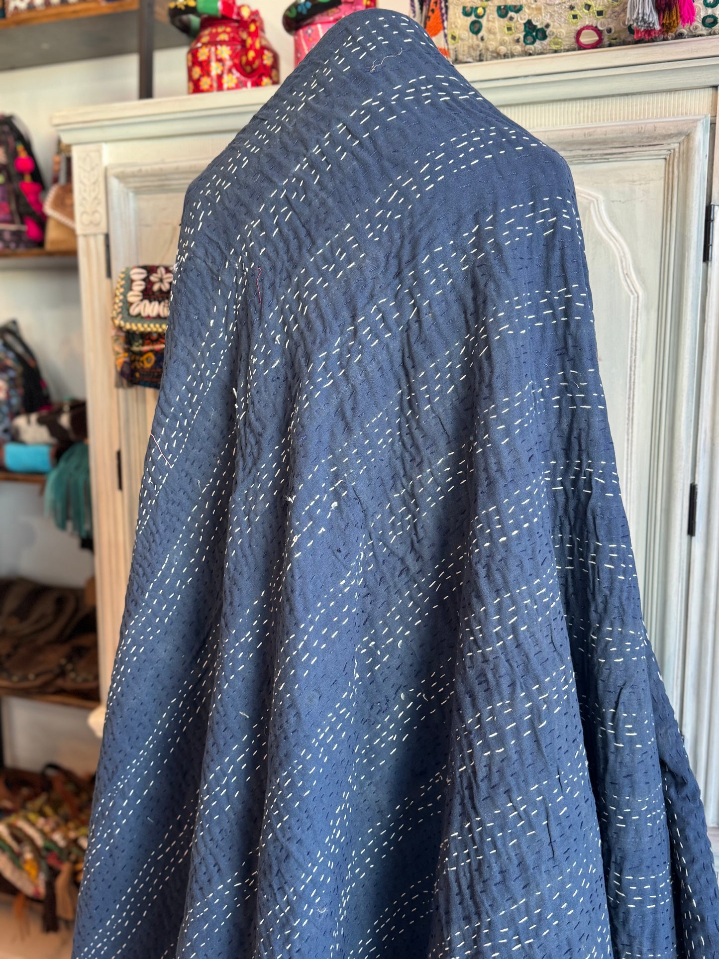 Showcasing tiny kantha stitches on the back of silk patchwork kantha quilt made of 160 patches