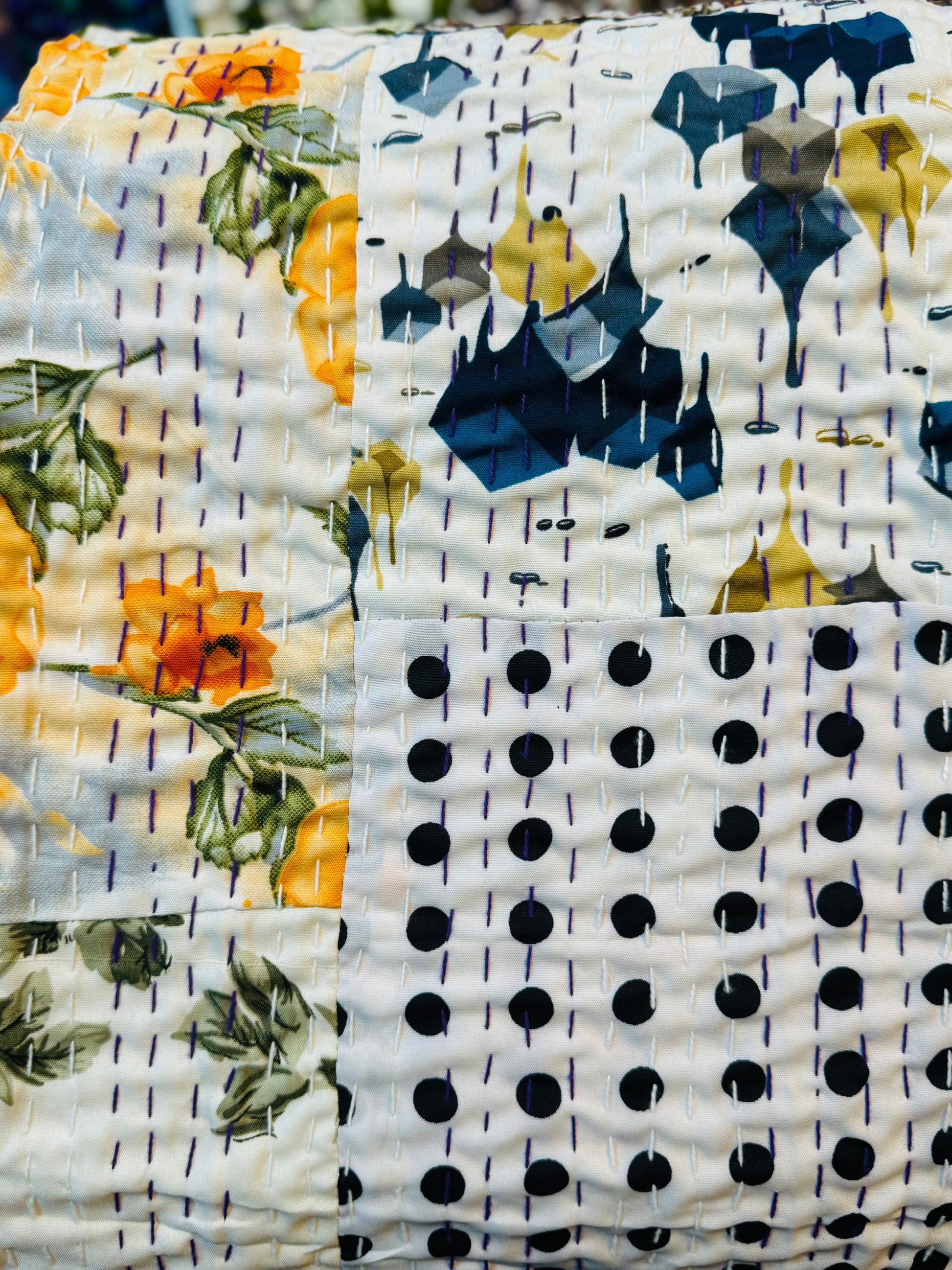 Close up of silk handmade silk patchwork kantha quilt with tiny stitches