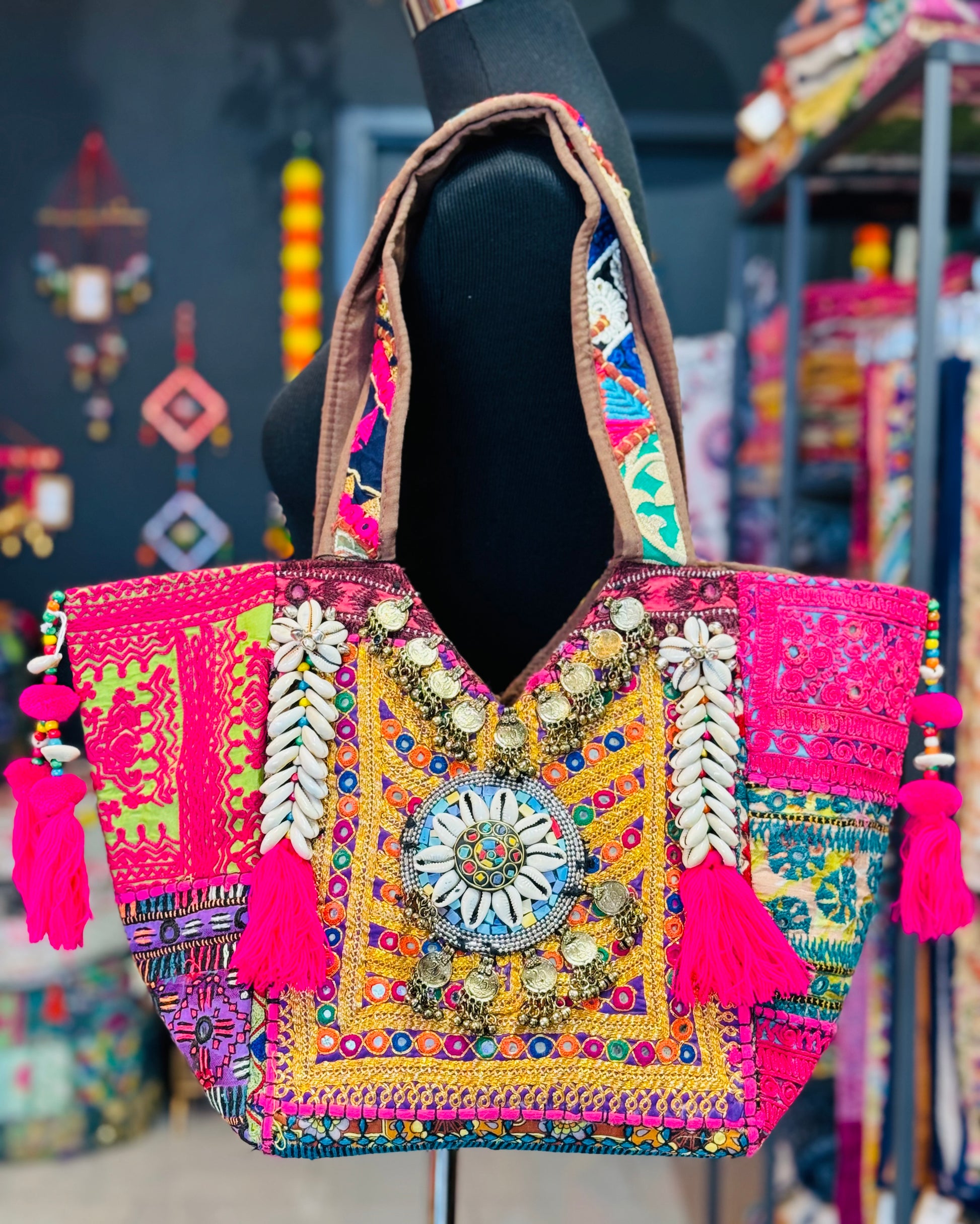 Handamde tribal tote bag in gold, pink and purple tones with shell embellishments, embroidery, and decorative coins
