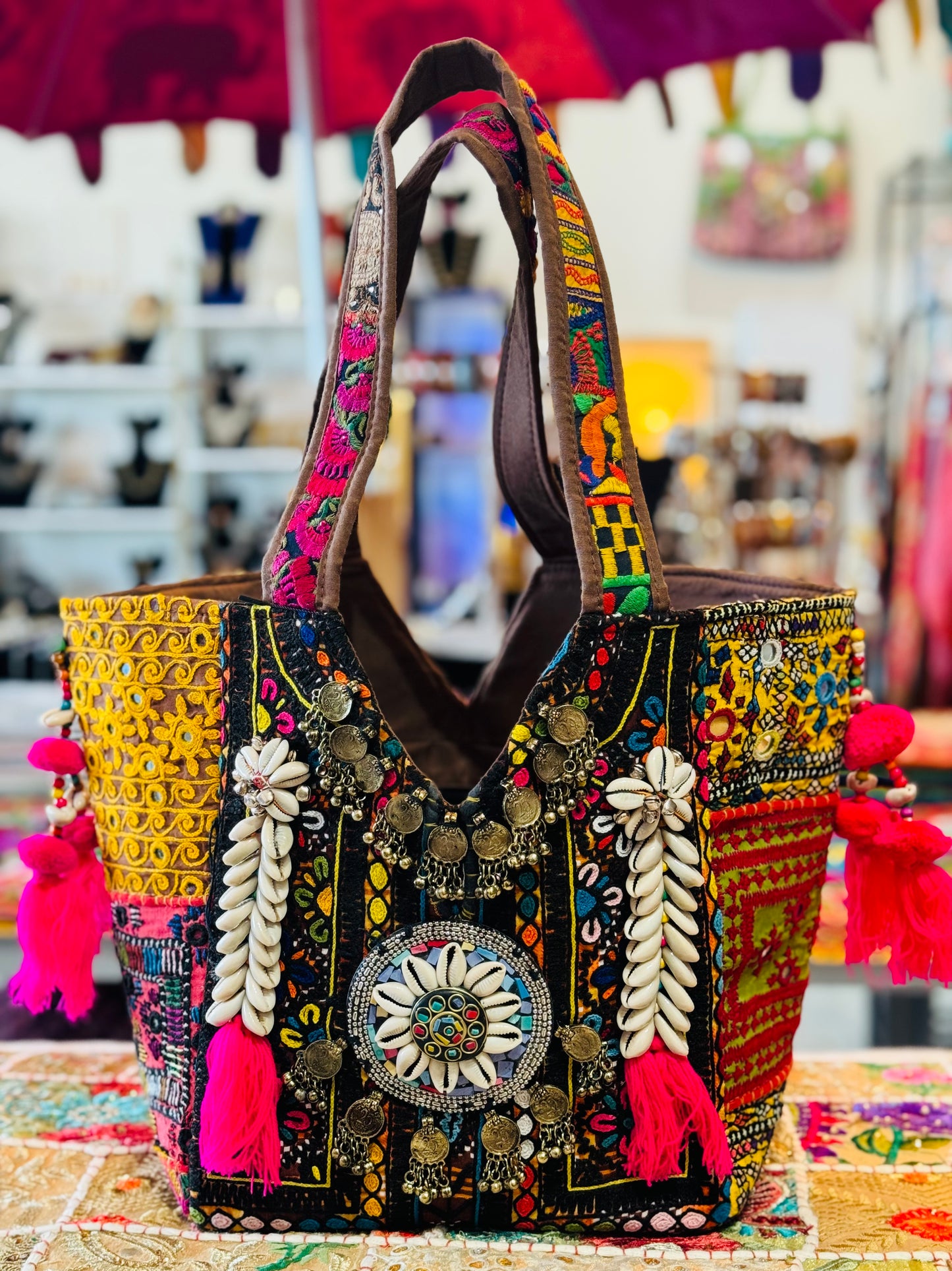 Black Banjara tote with bold patchwork in yellow, red, and pink featuring tassels, neads, and traditional indian mirror work