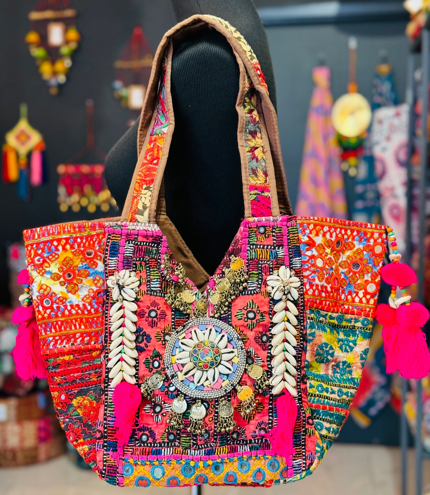 Vibrant Salmon patched banjara tote bag with multi color embroidered patches, mirror work, cowrie shells, hot pink tassels.