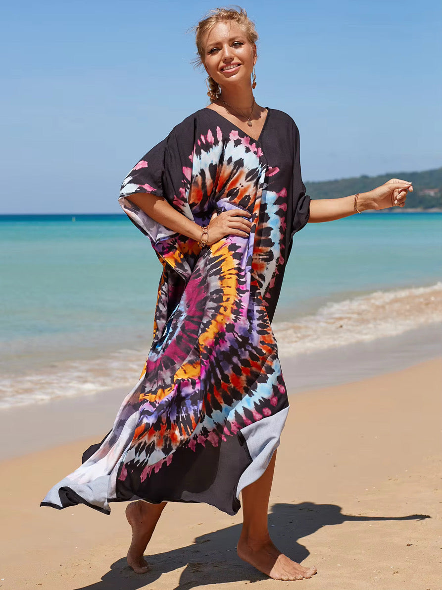 Woman wearing a colorful tie-dye dress on a beach