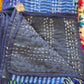 Close-up of a folded fabric with blue and multicolor patterns