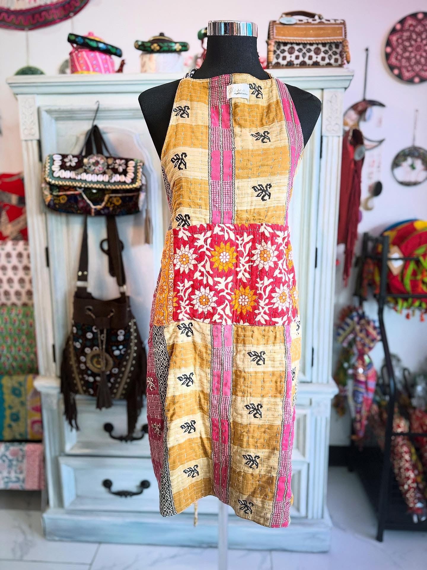 One side of Ocean Bloom apron in pink and gold patchwork with floral accents